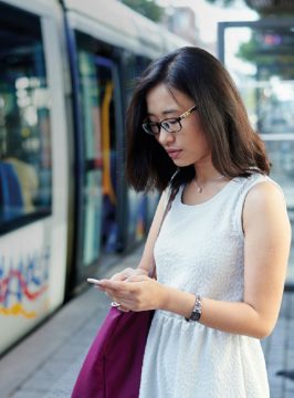 Woman on smartphone at station